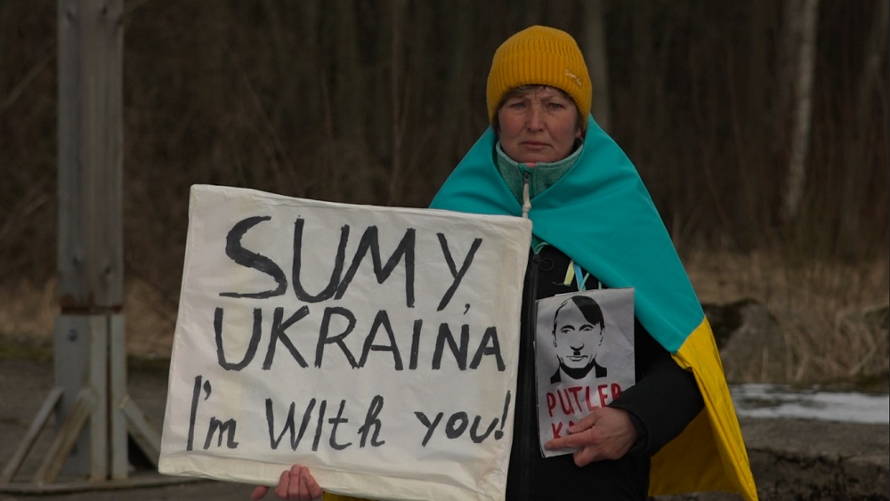 Ukrainiete, stāvot ceļa malā, 13 dienas pauž atbalstu Ukrainai