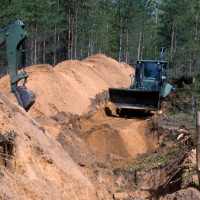 NBS kaujas inženieri šodien sāka meža ceļa pārrakšanu, izveidojot prettanku grāvi