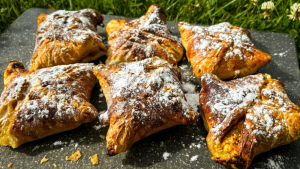 Kraukšķīgas biezpiena-zemeņu kabatiņas, kas ceptas airfryer friterī un apbērtas ar pūdercukuru.