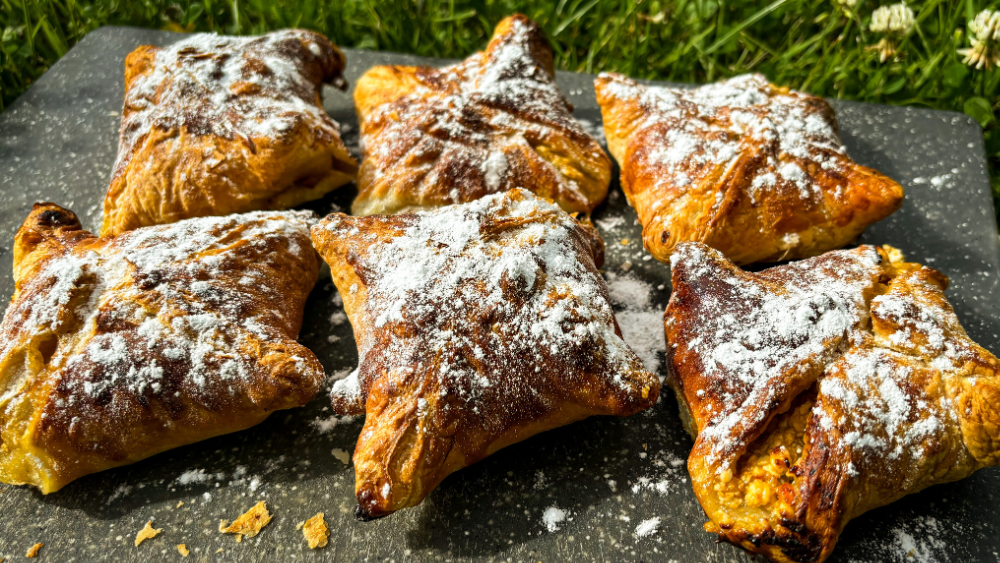 Kraukšķīgas biezpiena-zemeņu kabatiņas, kas ceptas airfryer friterī un apbērtas ar pūdercukuru.