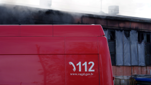Ugunsdzēsēju mašīna ar numuru 112 pie piedūmotas ēkas