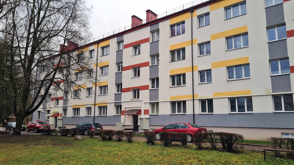 Siltināta daudzdzīvokļu māja Jēkabpilī ar krāsainu fasādi.