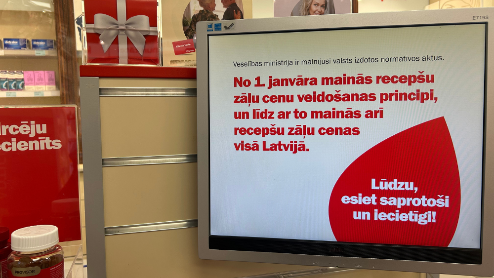 Informācijas displejs aptiekā par recepšu zāļu cenu veidošanas principu izmaiņām Latvijā.