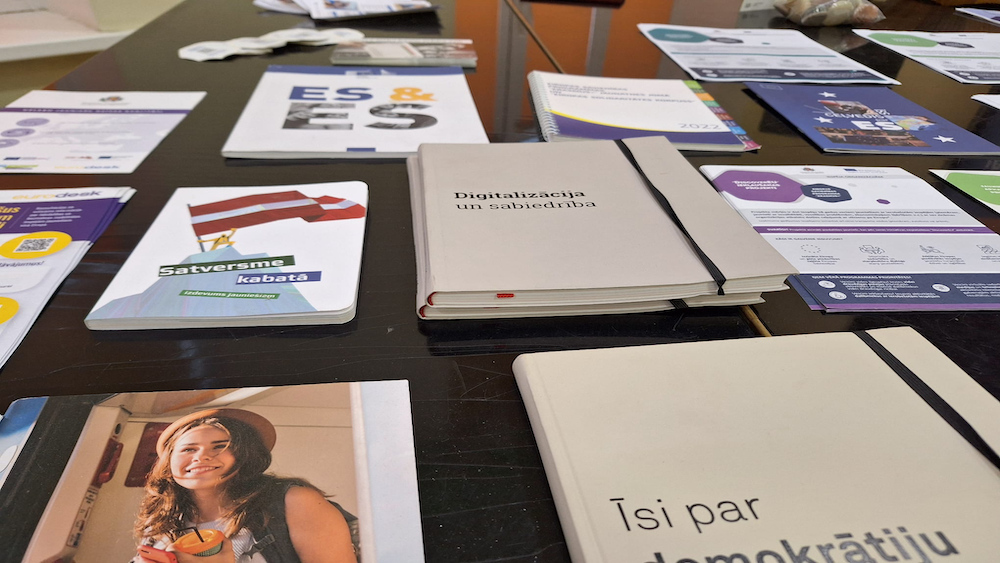 Materiāli par demokrātiju, vēlēšanām un digitālo sabiedrību uz galda.