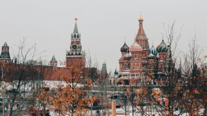 Maskavas Kremlis un Svētā Bazīlija katedrāle ziemas dienā ar koku zariem priekšplānā.