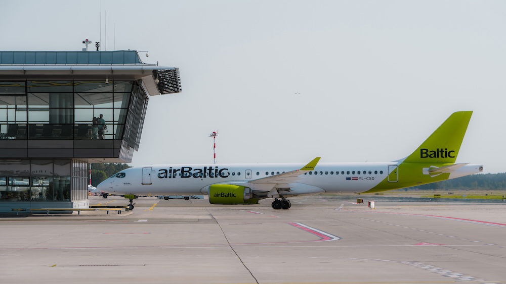 airBaltic lidmašīna uz skrejceļa pie lidostas termināļa
