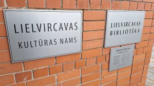 Lielvircavas Kultūras nama un bibliotēkas informatīvās zīmes uz ķieģeļu sienas.