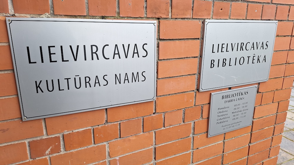 Lielvircavas Kultūras nama un bibliotēkas informatīvās zīmes uz ķieģeļu sienas.