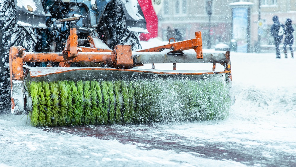 Tīrīšanas mašīna sniegotā ielā Kurzemē