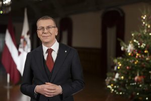 Valsts prezidents svētku uzrunas laikā telpā pie Latvijas karoga un Ziemassvētku eglītes