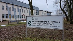 Latvijas Biotehnoloģiju universitātes Lauksaimniecības un Pārtikas tehnoloģijas fakultāte ar ceļazīmi priekšplānā.