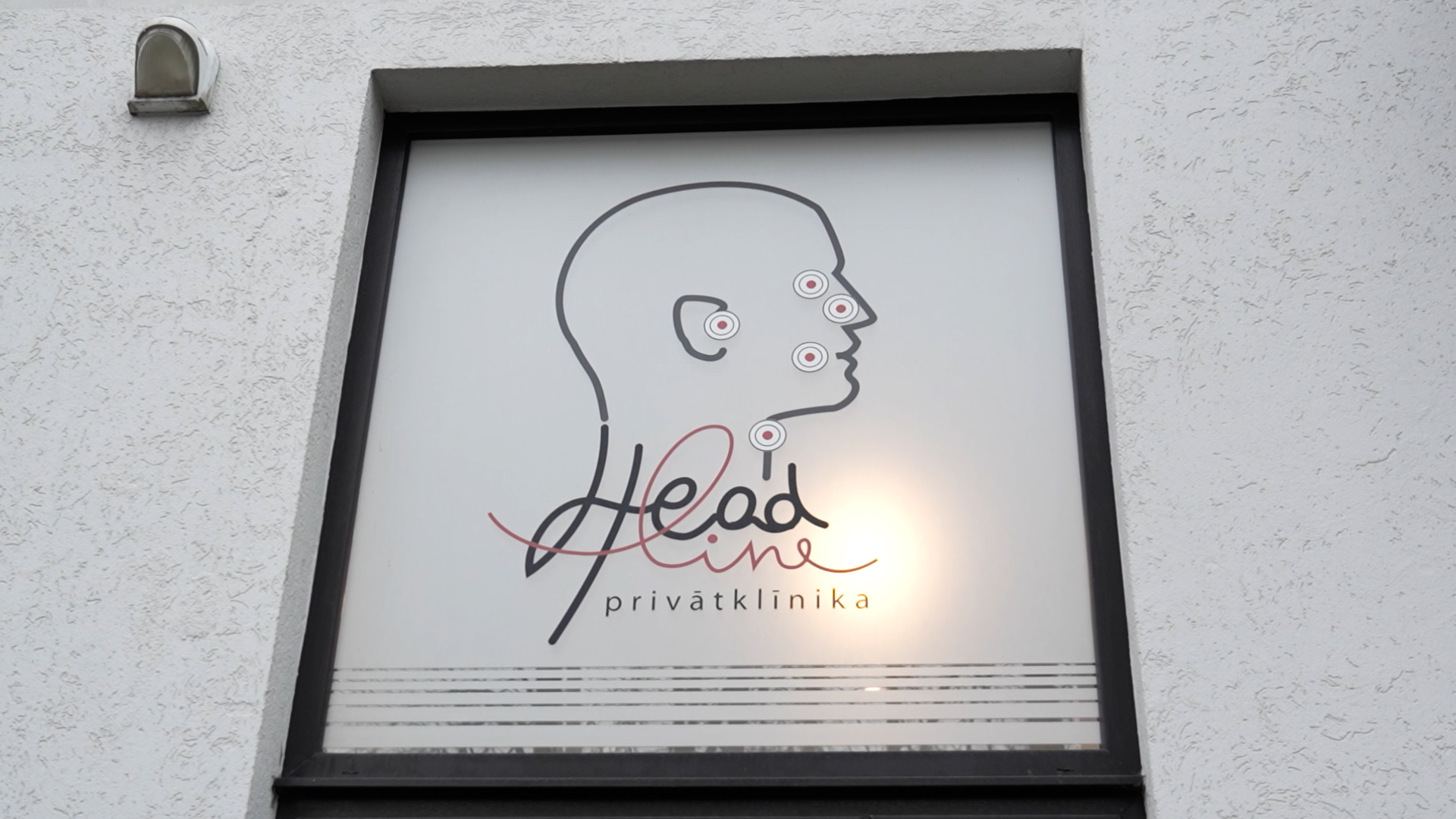 Head Line privātklīnikas logotips uz loga