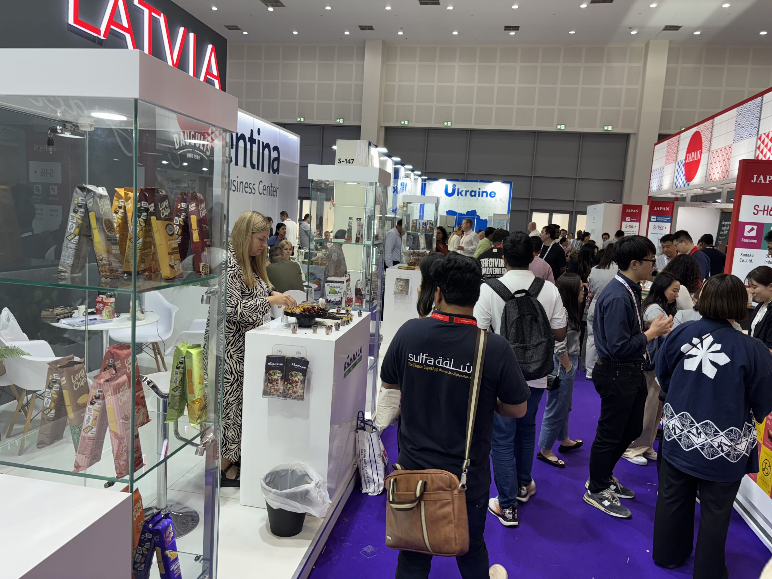 Latvijas stends izstādē “Gulfood” Dubaijā ar apmeklētājiem un pārtikas produktiem.