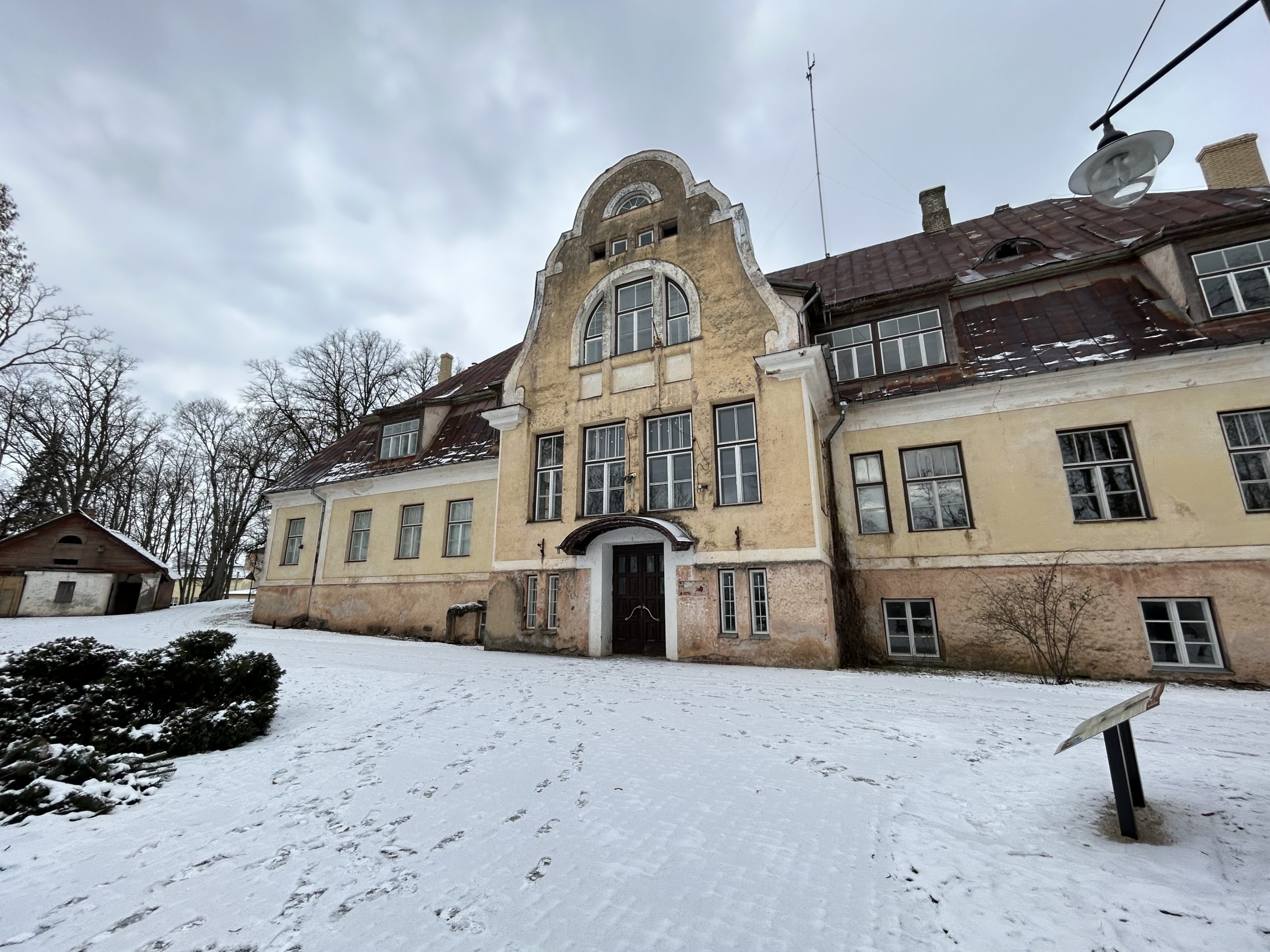 Vecbebru muiža ziemā ar sniegotu pagalmu.