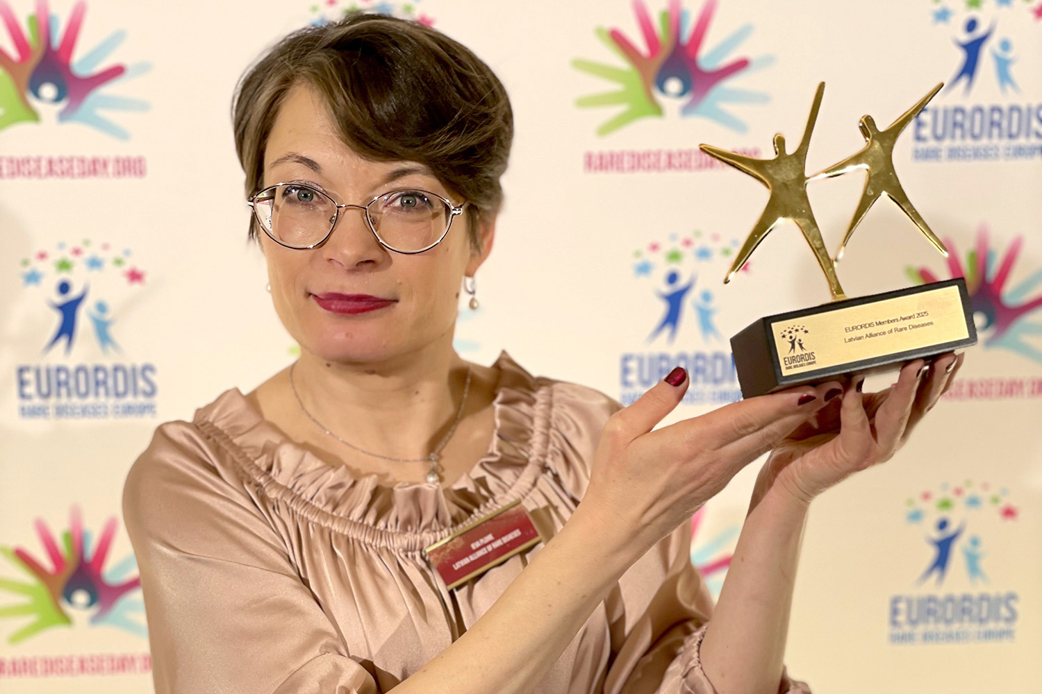Latvijas Reto slimību alianses valdes locekle Ieva Plūme ar EURORDIS Melnās Pērles 2025 balvu rokās.