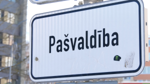 Ceļa zīme ar uzrakstu "Pašvaldība" pilsētvidē.