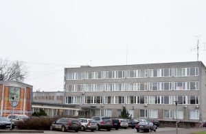 Aizkraukles novada pašvaldības ēka ar automašīnu stāvvietu priekšplānā.