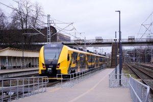 Jauns dzeltenmelns elektrovilciens stacijā uz sliedēm.
