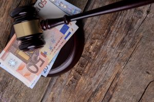 Tiesneša āmurs uz eiro banknotēm koka galda virsmā