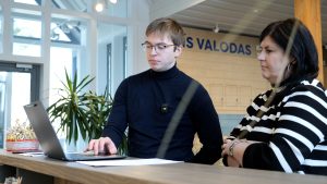 Franču brīvprātīgais un Talsu tūrisma speciāliste strādā pie datora, izstrādājot maršrutu franču tūristiem.