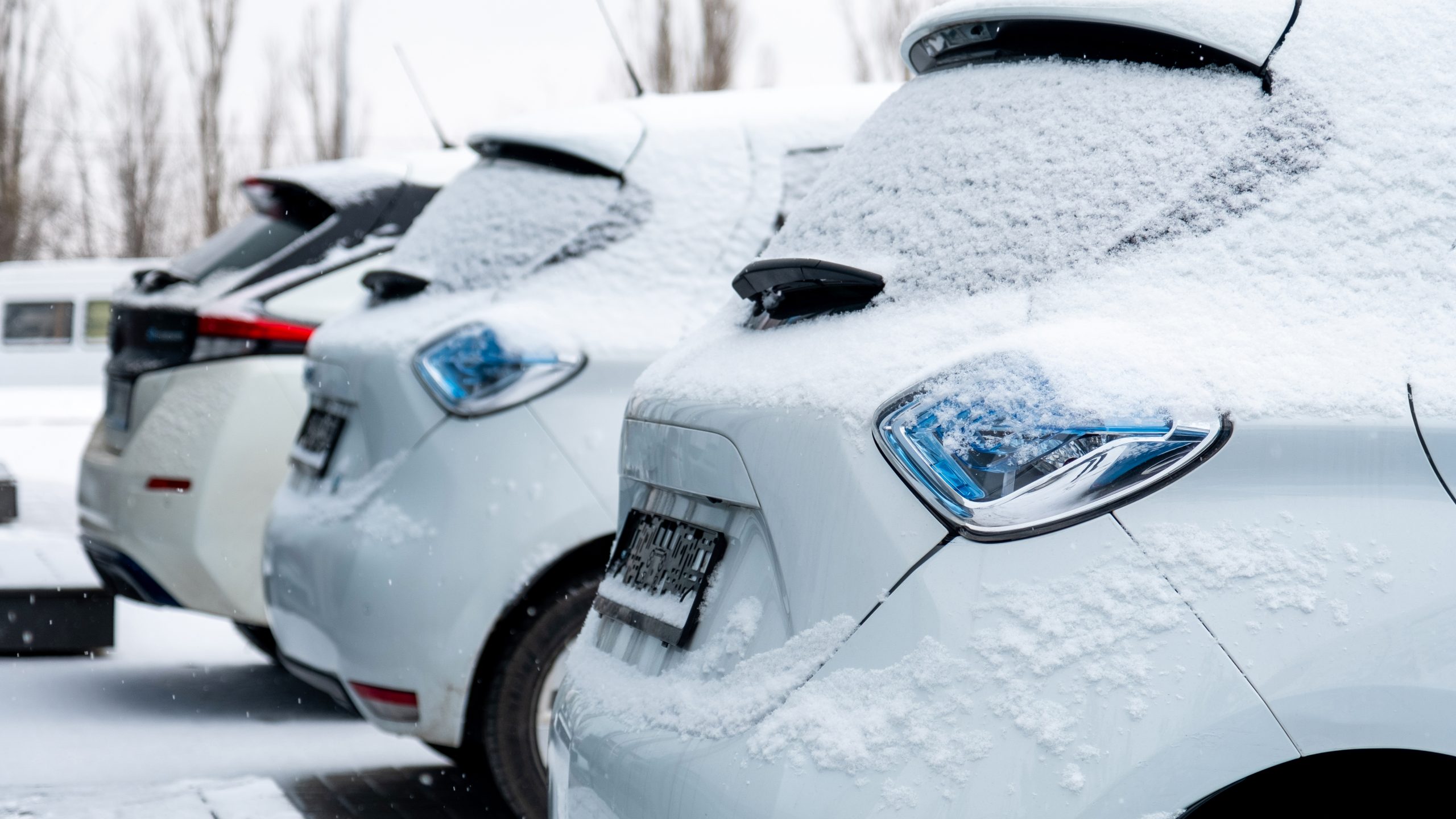 Elektriskie automobiļi ziemā ar sniega kārtu uz virsbūves