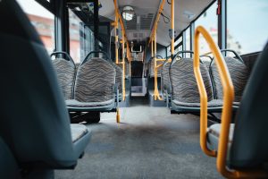 Tukšs sabiedriskais autobuss ar sēdvietām un dzeltenām margām.