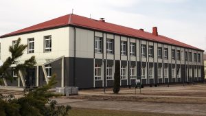 Lejasciema pamatskolas ēka ar sarkanu jumtu un mūsdienīgu fasādi.
