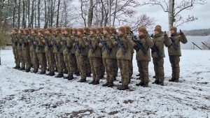 Jaunie karavīri ziemas formastērpos zvēr uzticību, stāvot ierindā sniegotā vidē