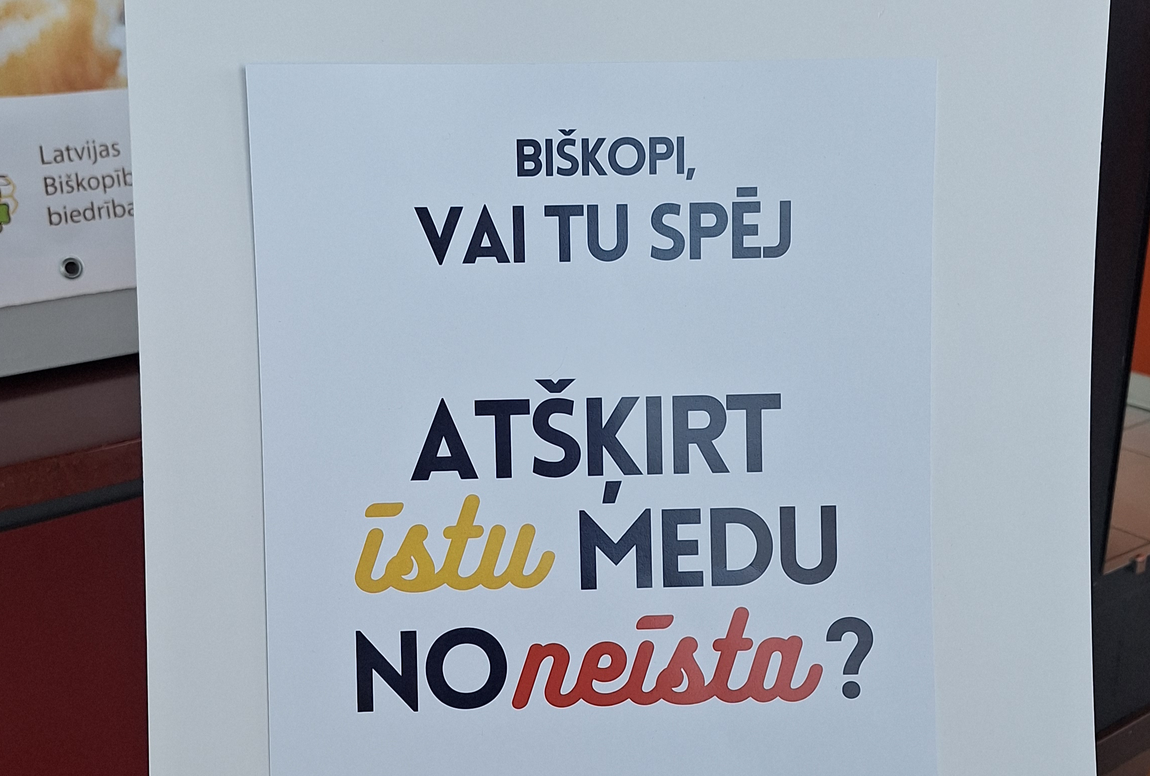Plakāts ar jautājumu par īsta un neīsta medus atšķiršanu