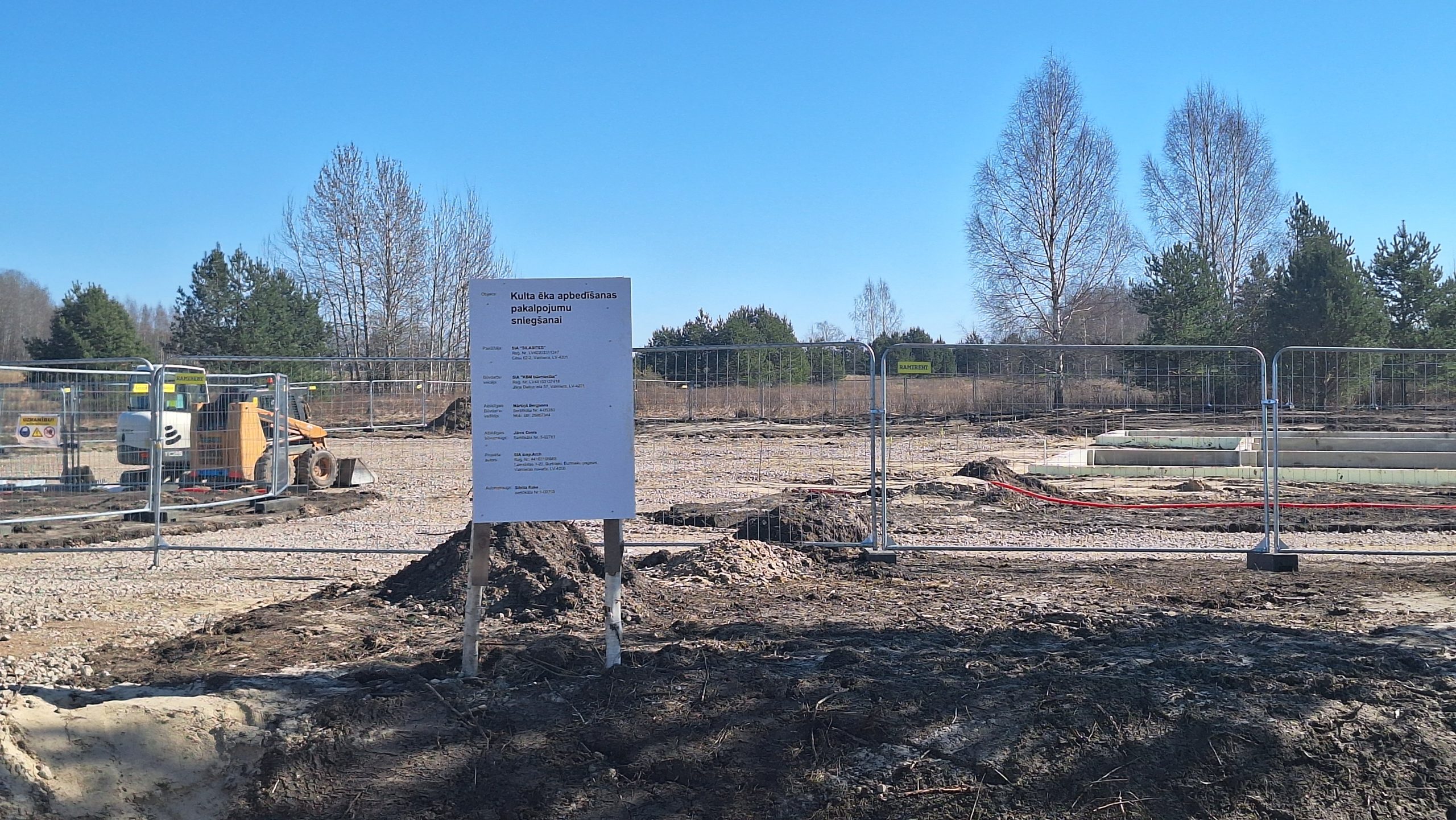 Būvlaukums ar informatīvu plāksni par kulta ēkas celtniecību.