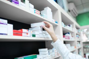 Farmaceita roka, kas no aptiekas plaukta izvēlas medikamenta kastīti