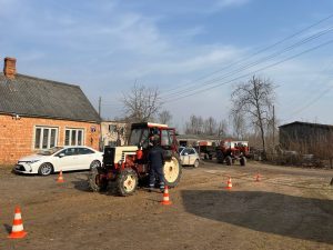 Traktors tehniskās apskates punktā lauku apvidū, inspektors veic pārbaudi.
