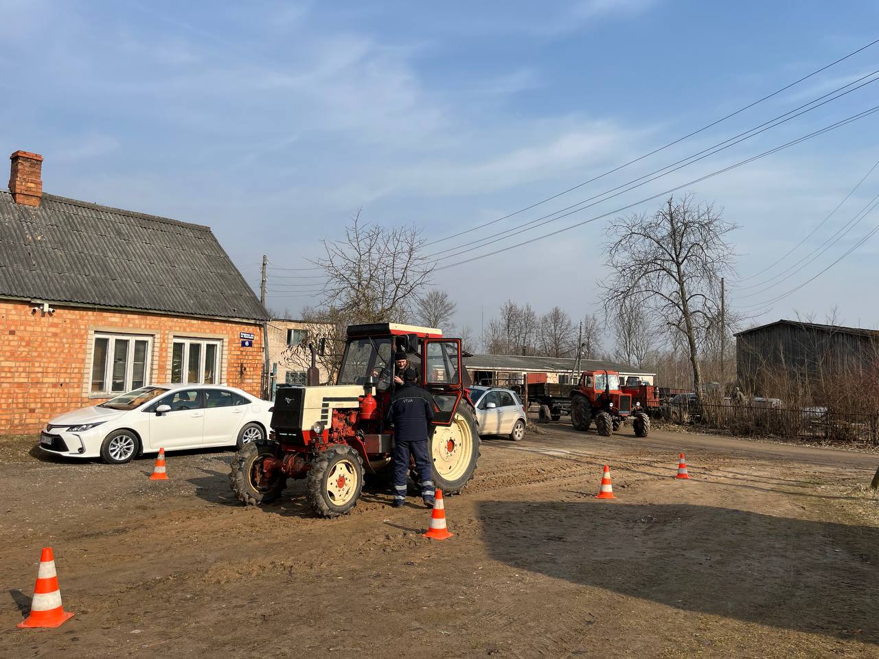 Traktors tehniskās apskates punktā lauku apvidū, inspektors veic pārbaudi.