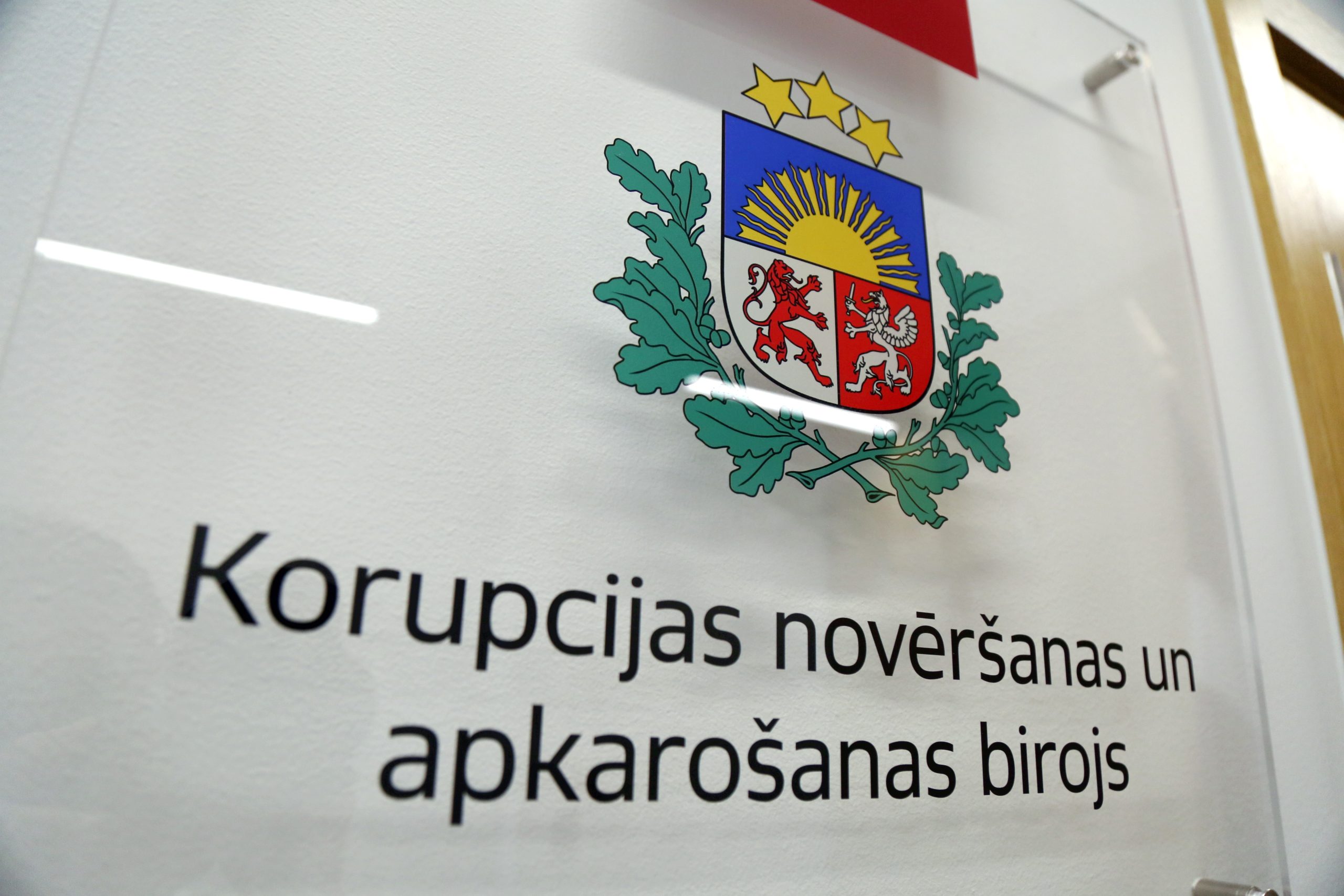 Korupcijas novēršanas un apkarošanas biroja (KNAB) plāksne ar Latvijas ģerboni.