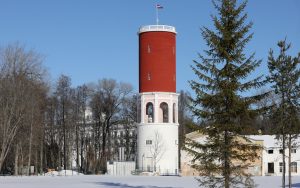 Ķemeru ūdenstornis ar Latvijas karogu ziemas ainavā.