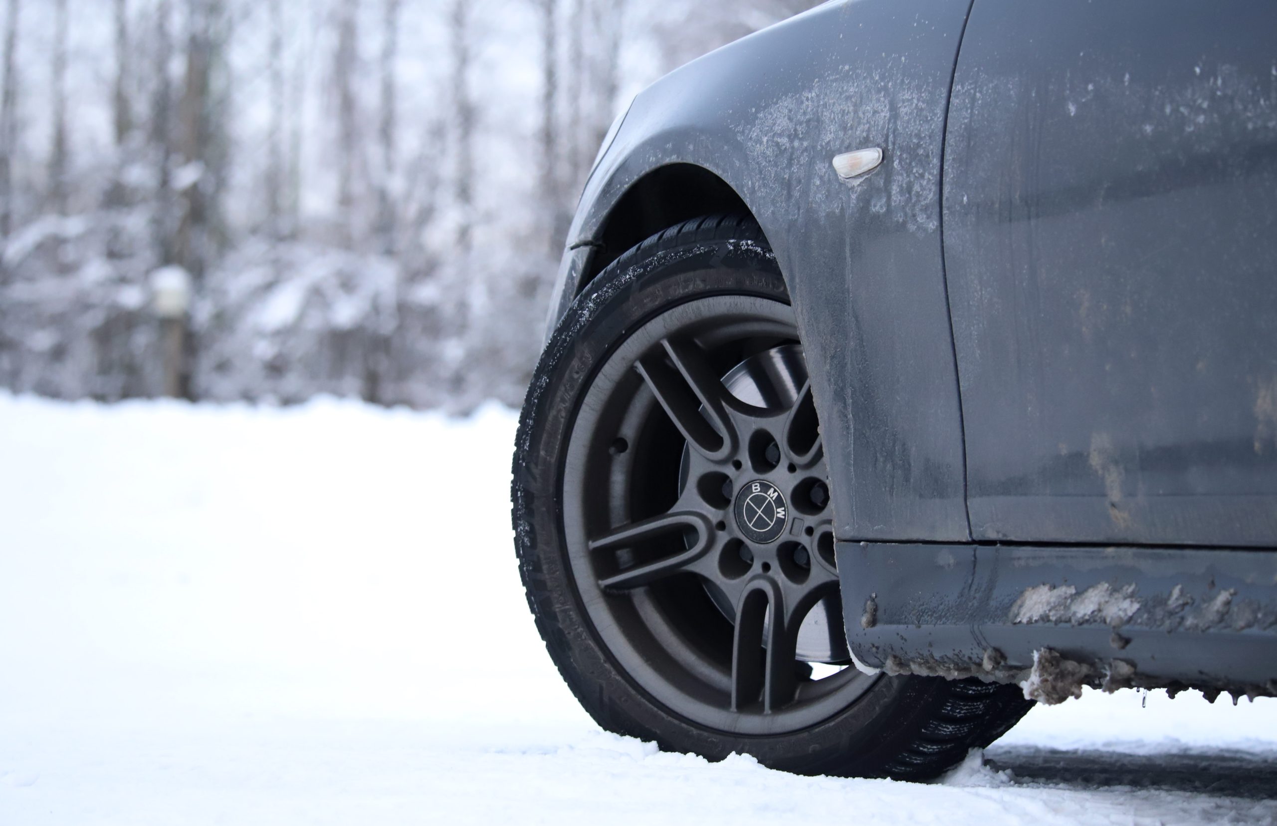 Auto riepa un disks ziemas apstākļos ar sniegu fonā