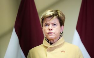 Latvijas ārlietu ministre Baiba Braže mētelī preses konferencē, fonā redzami Latvijas karogi
