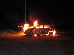 Degoša automašīna naktī, liesmas pārņēmušas salonu un motora daļu