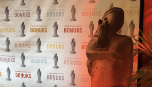 Latgaliešu kultūras gada balvas "Boņuks" statuja un pasākuma fons.