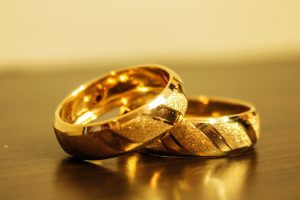 Zelta kāzu gredzeni tuvplānā uz koka virsmas