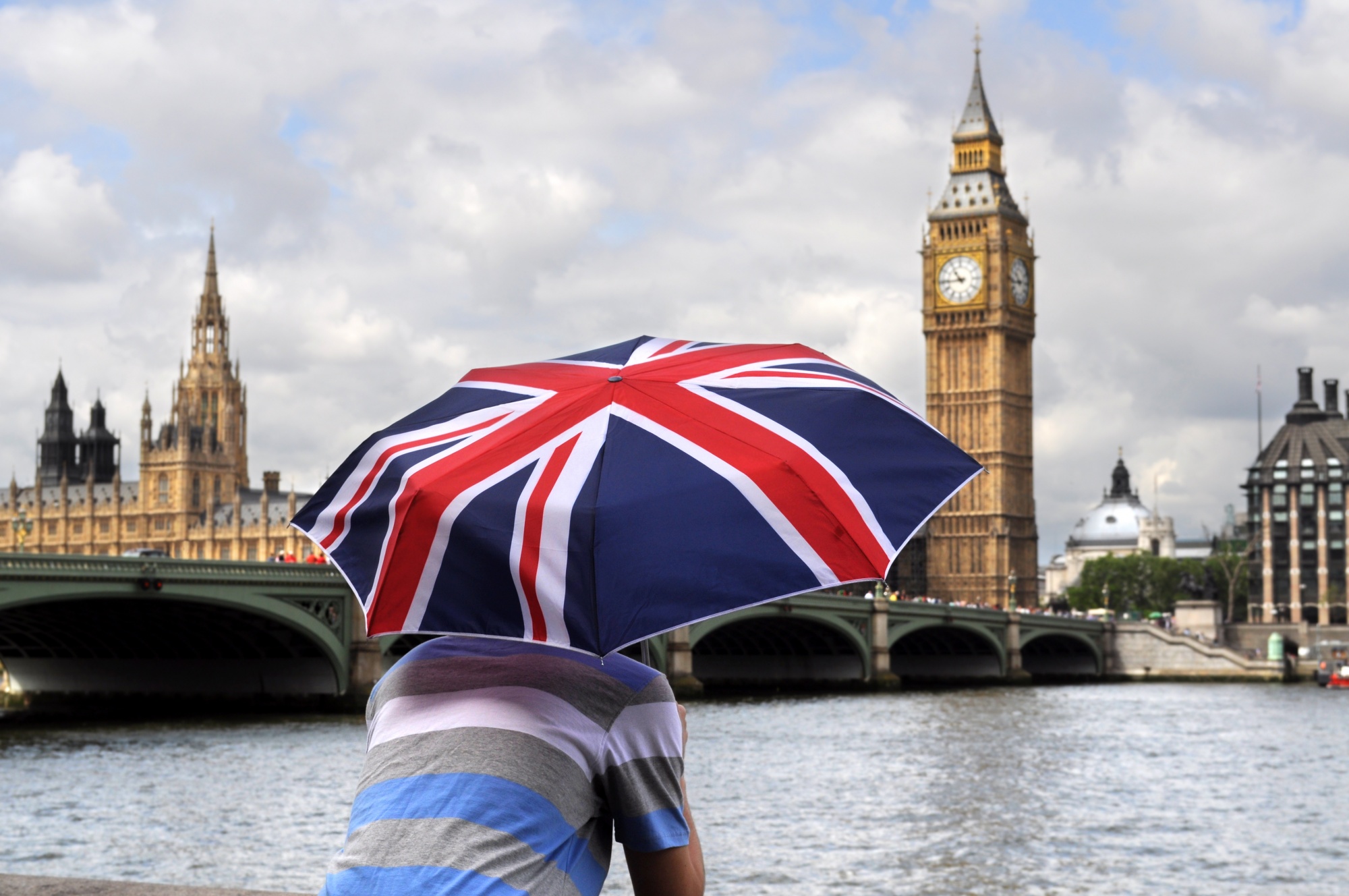 Cilvēks ar Lielbritānijas karoga lietussargu pie Temzas Londonā