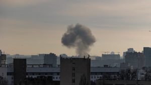Sprādziena izraisīts dūmu mākonis virs pilsētas ēkām.
