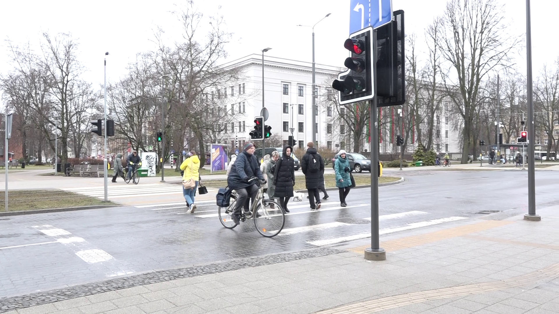 Gājēji un velosipēdists šķērso ielu pie luksofora Liepājā
