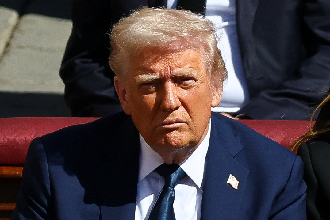 Donalds Tramps tumšā uzvalkā pasākumā zem atklātām debesīm