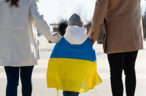 Bērns ar Ukrainas karogu starp diviem pieaugušajiem