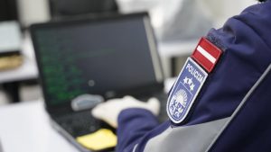 Latvijas policijas darbinieks pie datora, analizējot datus kiberdrošības jomā
