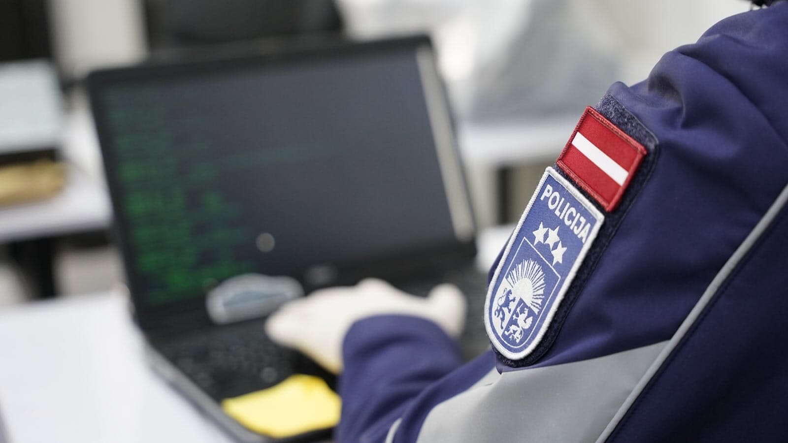 Latvijas policijas darbinieks pie datora, analizējot datus kiberdrošības jomā