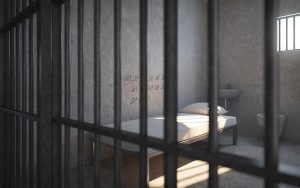 Tukša cietuma kamera ar gultu, izlietni, tualeti un dienu atzīmēm uz sienas