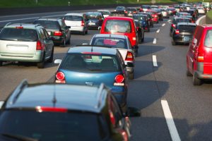Auto sastrēgums uz vairāku joslu šosejas saulainā dienā