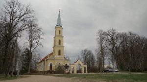 Zaļenieku luterāņu baznīca ar augstu torni pelēkā pavasara dienā